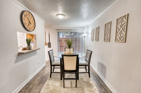 a dining room with a table and chairs and a clock on the wall